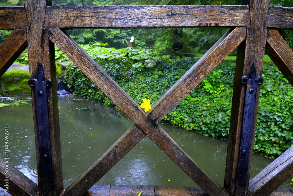 Yellow leaf lies on wooden fence on bridge over small river in autumn park. Leaf fall. Calendar, postcard of seasons, Yellow leaf lies on wooden fence on bridge over small river in autumn park. Leaf fall. Calendar, postcard of seasons,