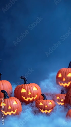 Halloween pumpkins glowing in the fog against a dark blue background.