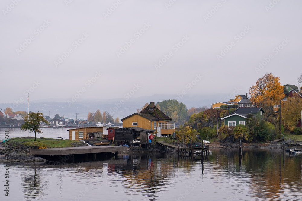 Oslo, Norway - October 20, 2024: Oslofjord (Oslofjorden), view of summer houses and cottages. Frame houses for recreation. Hut among the forest and rocks. Multicolored private houses.