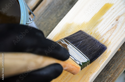 Fototapeta Naklejka Na Ścianę i Meble -  The concept of carpentry and wood preservation - painting wooden boards with linseed oil varnish.