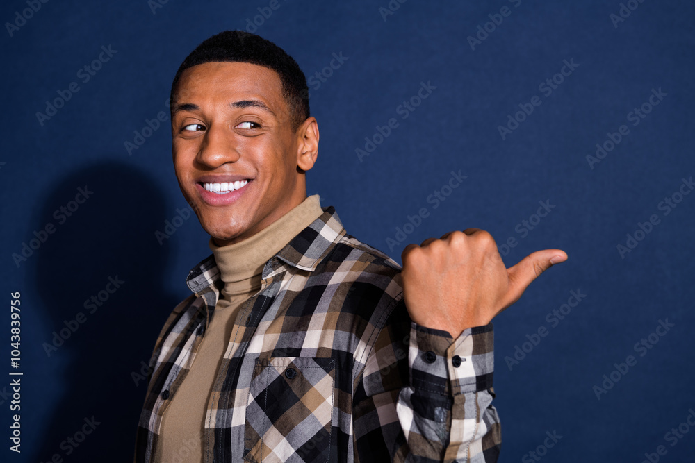 Photo portrait of handsome young man look point empty space dressed stylish plaid garment isolated on dark blue color background Photo portrait of handsome young man look point empty space dressed stylish plaid garment isolated on dark blue color background