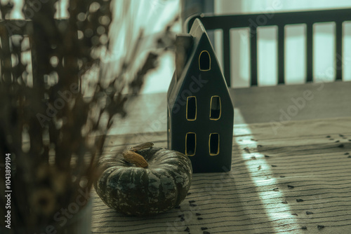 cozy autumn indoor interior decoration, seramic black house european style object, gray green pumpkin, table runner, day light through window linen curtains photo