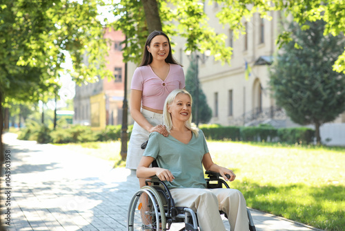 Senior woman in wheelchair and her daughter spending time together outdoors