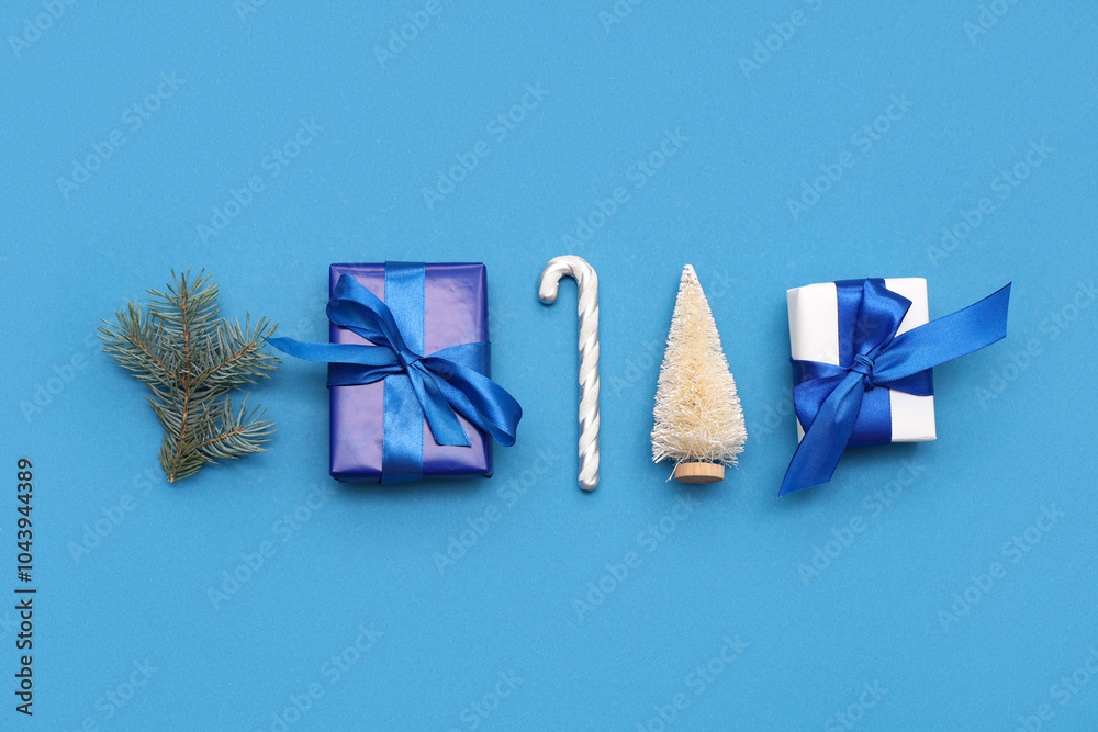 Fototapeta premium Festive composition with gift boxes and Christmas decorations on blue background
