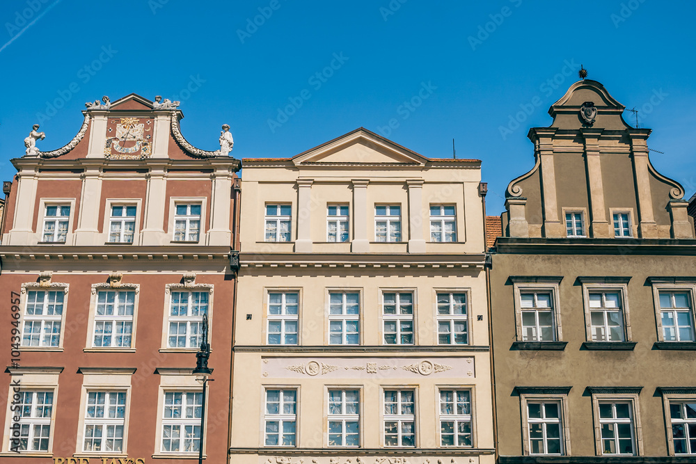 Colorful Historic Buildings and Houses on Stary Rynek Square in Poznań, Poland, with a Blue Sky and Mural Art