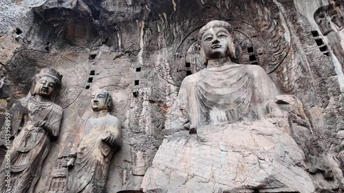 Luoyang Longmen, China: Dramatic pan footage of the famous statues and the Big Vairocana Buddha in the Longmen grottes Fengxian main cave that dates back from the 7th century in Central China.