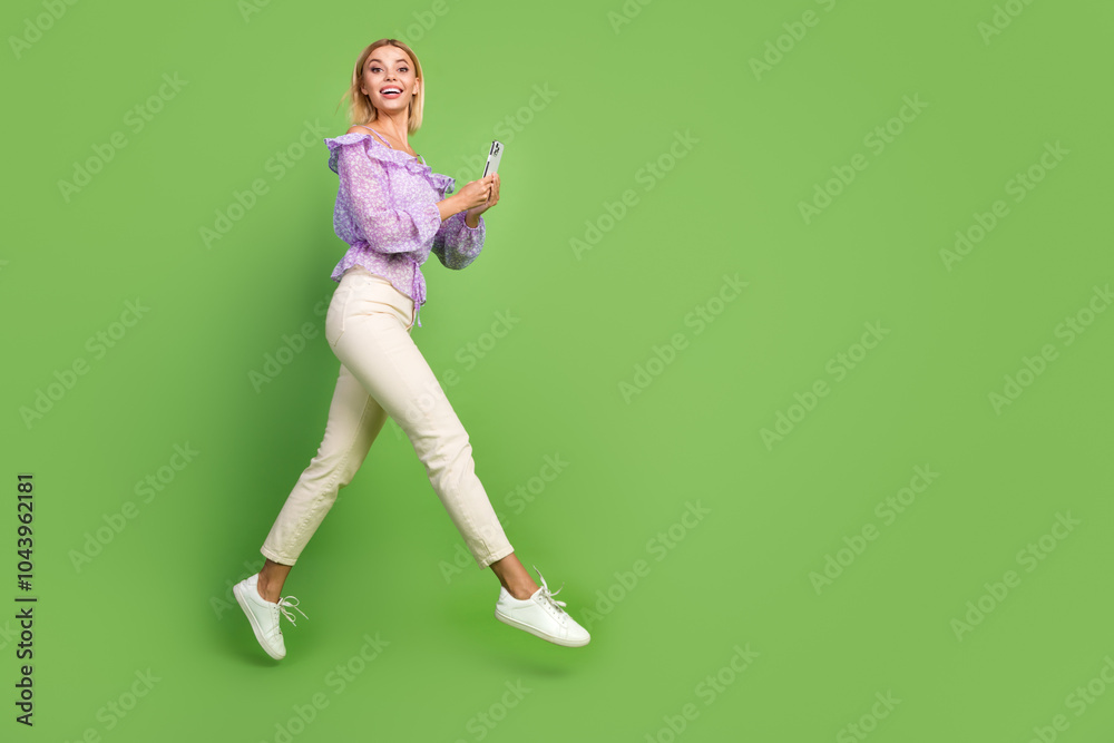 Photo of cheerful adorable girl wear stylish clothes going empty space isolated on green color background Photo of cheerful adorable girl wear stylish clothes going empty space isolated on green color background