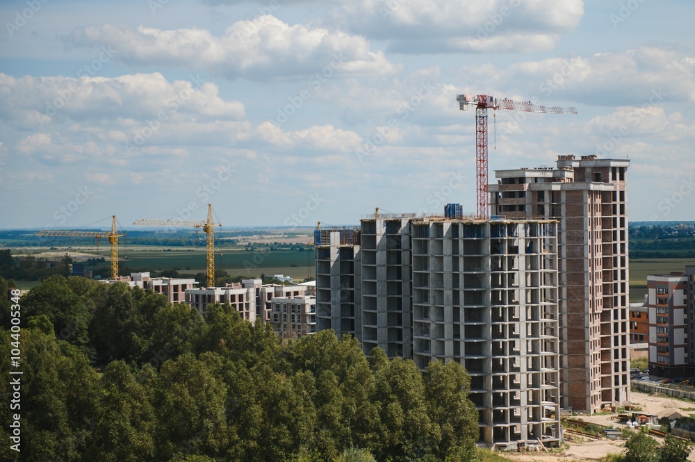 Tower cranes in close-up on the background of a multi storey building under construction Tower cranes in close-up on the background of a multi storey building under construction