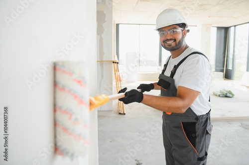 painter doing painting work on wall with roller. concept of hard working, home renovation