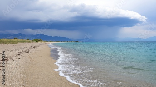 A quiet beach lies under a darkening sky as waves begin to rise photo