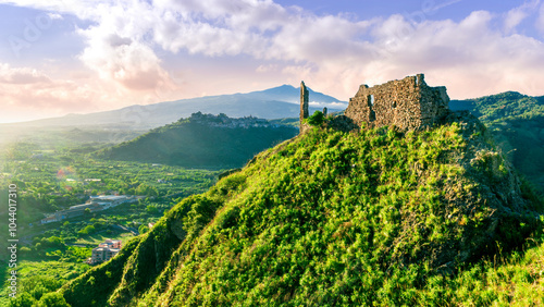 beautiful scenic sunset landscape of a wonderful mountain with old castle ruin on top and green valley and amazing high mountain highland with nice cloudy sky on background photo