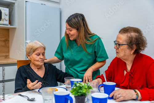 Nurse and senior women smiling and talking at dining room