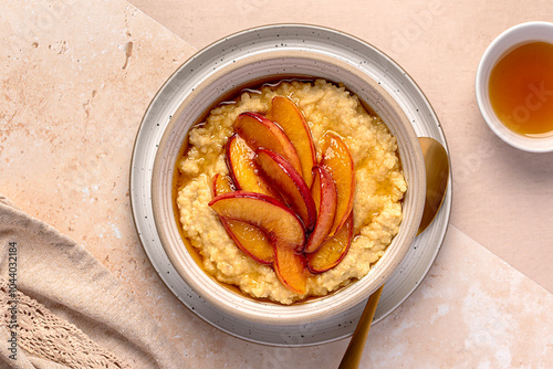 Macro food photography of millet porridge with caramelized peach, nectarine with agave syrup and almond milk; honey