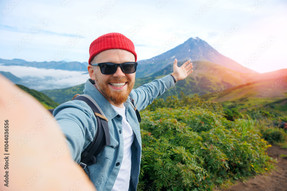 Naklejka premium Adventure action photo, traveler man make selfie on background Vilyuchinsky volcano, trip Kamchatka Russia