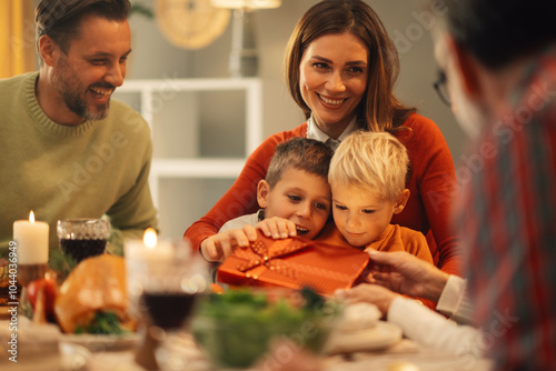 Happy family having christmas dinner at home and opening gifts