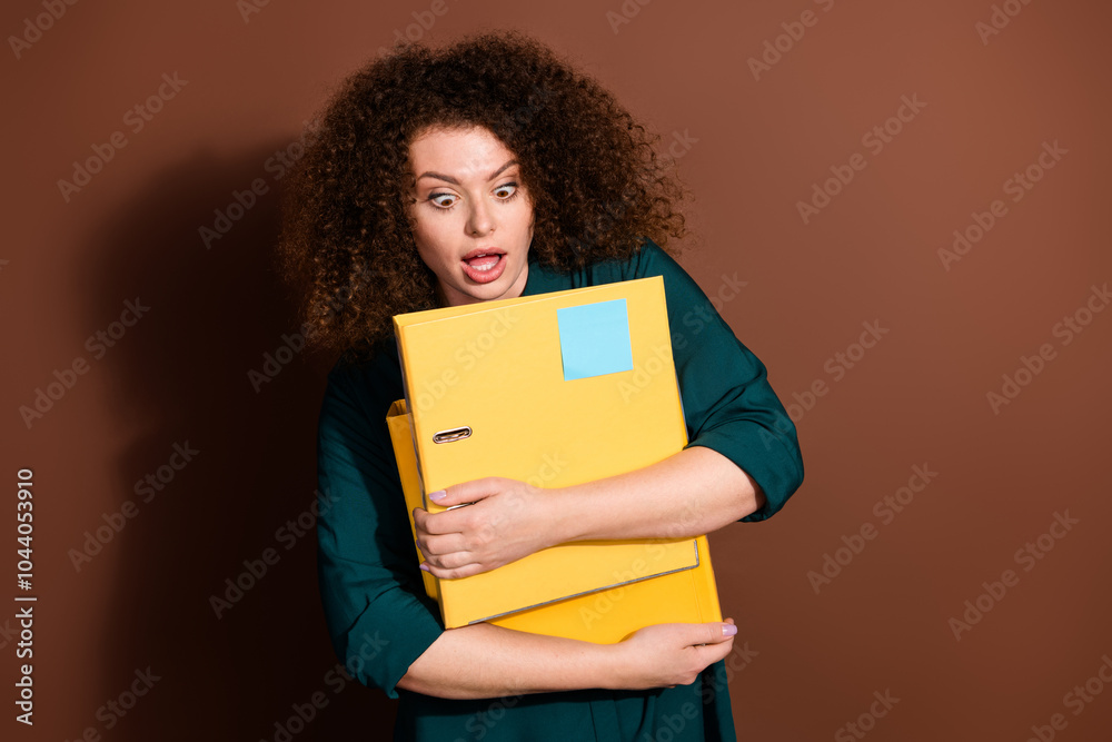 Photo of adorable impressed woman wear formal shirt holding documents folders empty space isolated brown color background Photo of adorable impressed woman wear formal shirt holding documents folders empty space isolated brown color background