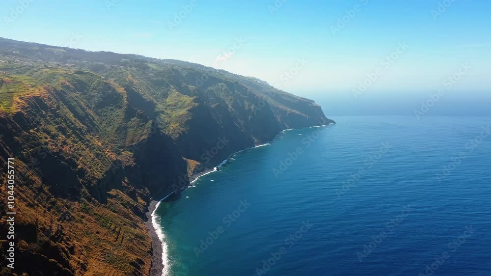 Beautiful rocks descending into the Atlantic Ocean. Mountainous shore of Madeira, Portugal on sunny day. Top perspective. Beautiful rocks descending into the Atlantic Ocean. Mountainous shore of Madeira, Portugal on sunny day. Top perspective.