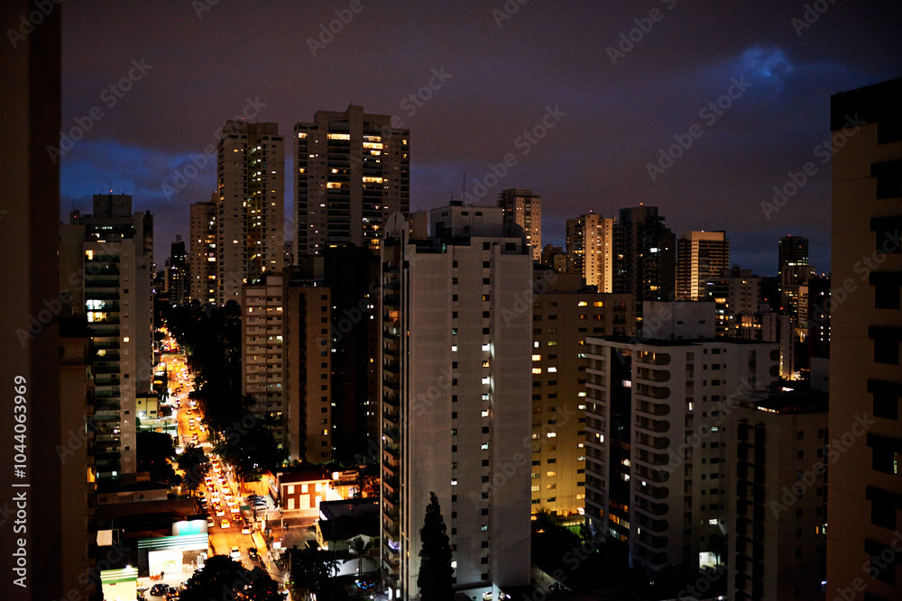 Fototapeta premium Cityscape, metro and buildings at night for development, infrastructure and road for transport. Urban, lights and architecture exterior with scenery for property, facade and skyline in New York