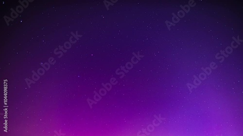 Night sky with aurora borealis as time lapse video. Abstract background of the stars and violet magenta colors due to polar light effects. The beautiful rays are moving through the frame. photo