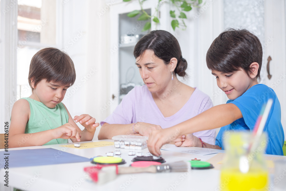 Mother and child are sitting at a desk, working on a craft project Mother and child are sitting at a desk, working on a craft project