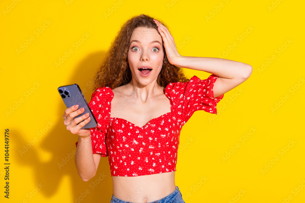 Naklejka premium Photo portrait of pretty young girl shocked hold device wear trendy red outfit isolated on yellow color background
