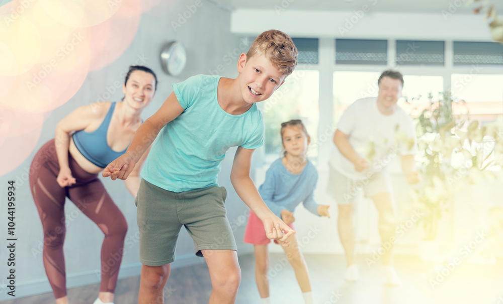 Fototapeta premium Family with two children engaged in active dancing in fitness studio