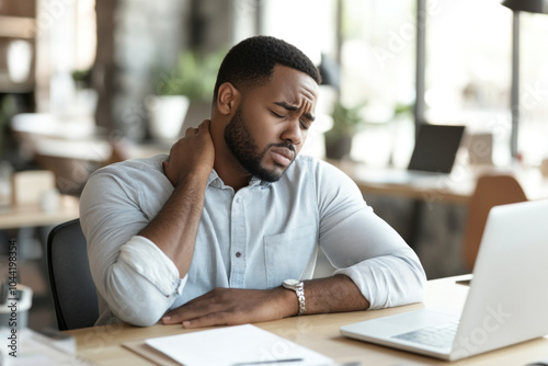 A man at his desk, head in hands, looking worried and overwhelmed.