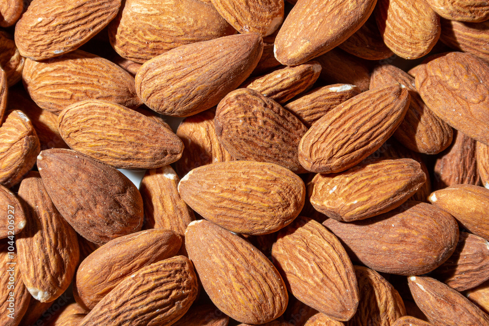 Fototapeta premium Scattered Almonds. Background from Almond Nuts. Natural High-Calorie Snacks