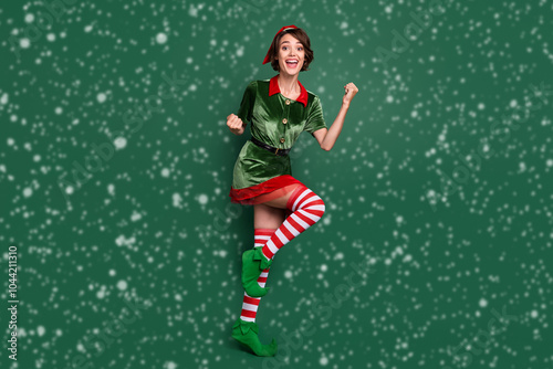 Full length body size view of attractive lucky girl dancing having fun rejoicing isolated over green color background