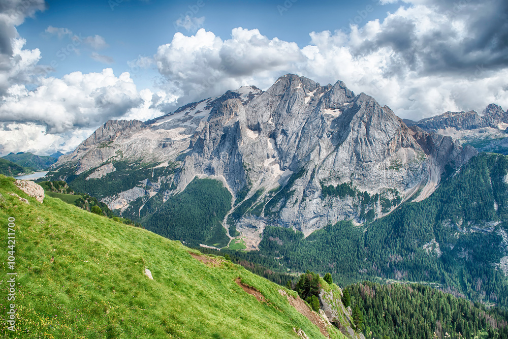 Fototapeta premium Marmolada mountain range towering over green valley, Dolomites, Italy