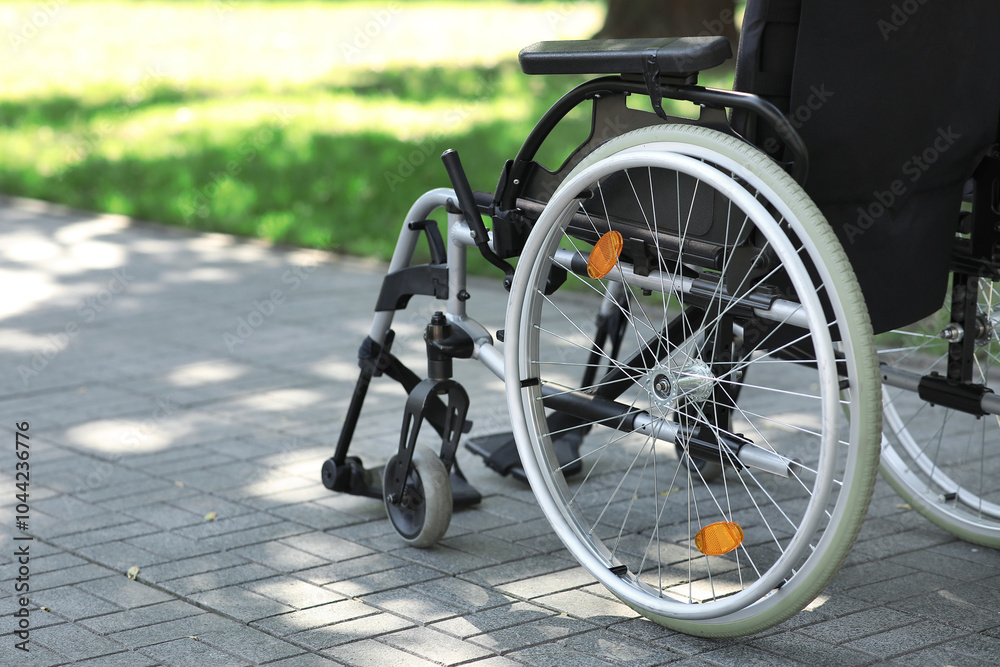 Wheelchair on paved road outdoors, closeup Wheelchair on paved road outdoors, closeup