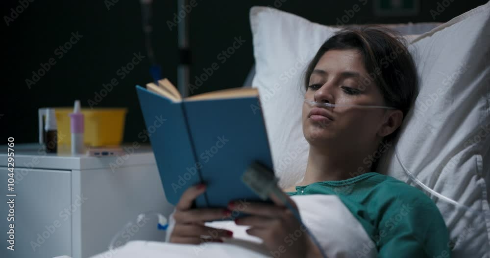 Patient in hospital ward with book in hands reads while recovers. Patient in hospital ward with book in hands reads while recovers.