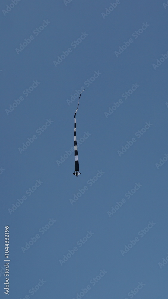 view of the blue sky with mountains and roofs of houses, in the sky there are kites