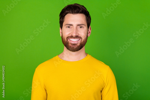 Photo of good mood positive nice man with stylish beard dressed yellow shirt toothy smiling isolated on vibrant green color background