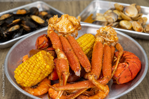 Seafood cajun feast with shellfish choices for dinner with the snow crab legs, lobster, corn, and shrimp up front