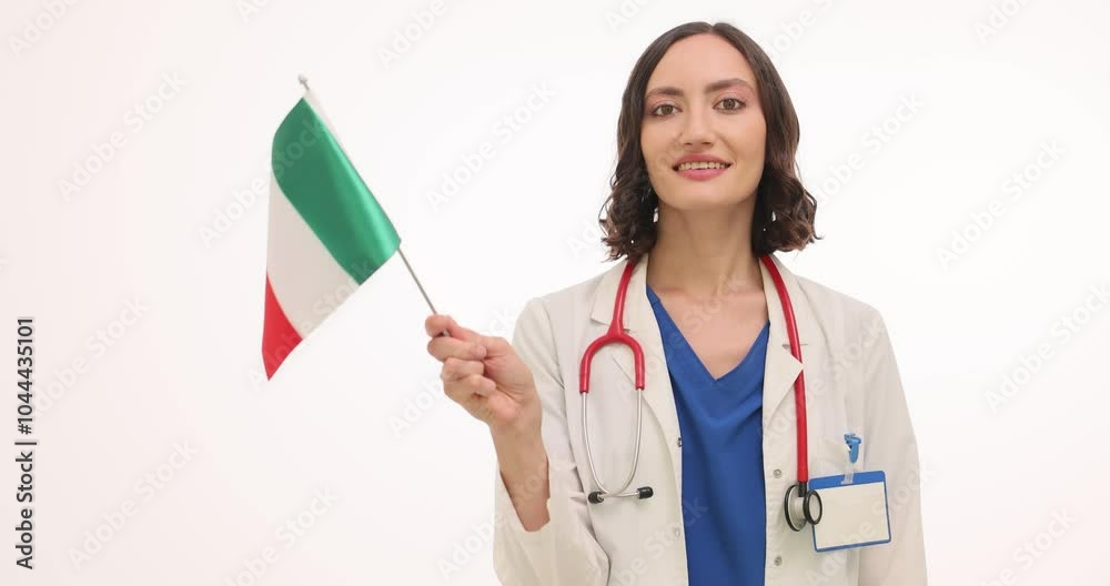 Woman doctor in uniform proudly waves Italian flag on white background. Brunette medic with stethoscope shows will to visit country slow motion Woman doctor in uniform proudly waves Italian flag on white background. Brunette medic with stethoscope shows will to visit country slow motion