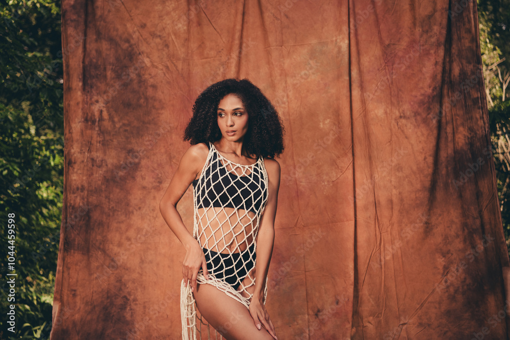 Fototapeta premium Photo of lovely charming lady advertising stylish clothes collection in forest on brown textile background