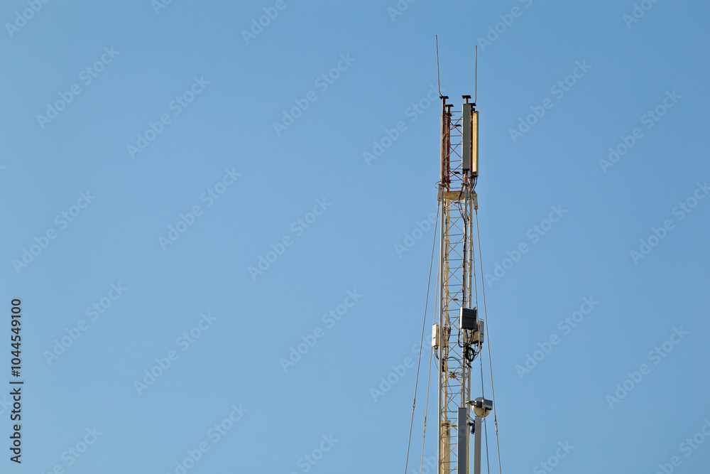 Cellular tower. Telecommunication cell tower against clear blue sky. The structure is equipped with antennas and cables used to transmit the mobile network signal. Cellular tower. Telecommunication cell tower against clear blue sky. The structure is equipped with antennas and cables used to transmit the mobile network signal.