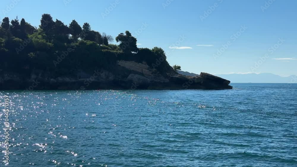 Blue shimmering sea and rocky coast overgrown pines. Blue shimmering sea and rocky coast overgrown pines.