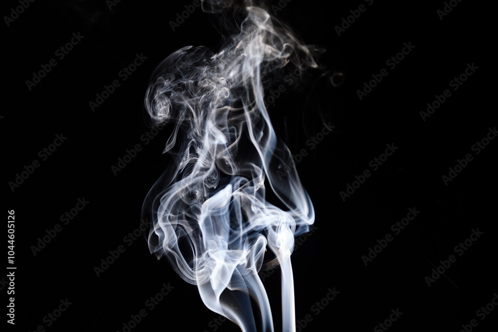Obraz premium Mysterious wisps of smoke dance gracefully against a dark background at twilight