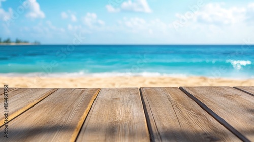 Wooden deck surface with a blurred backdrop of a sandy shore and azure ocean High quality image