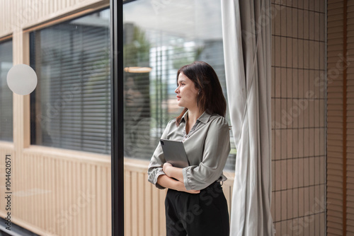 Confident Business Woman Standing in Modern Office Environment with Professional Attire and Poised Demeanor