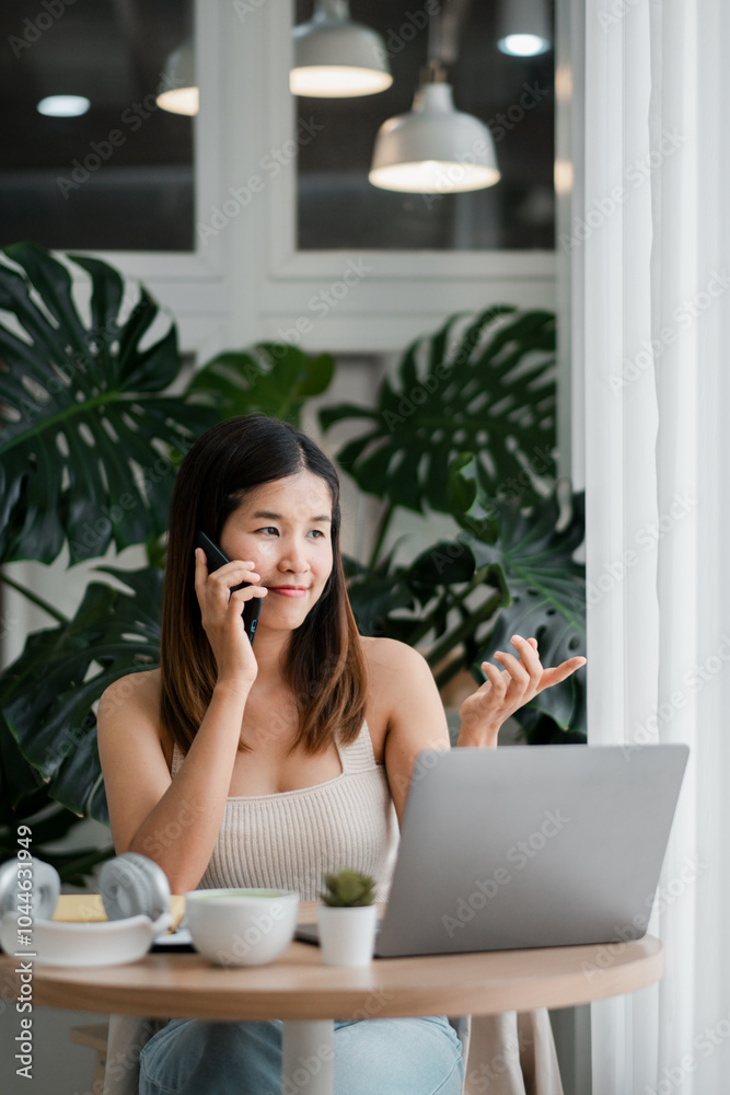 Smiling woman multitasking with a laptop and smartphone in a cozy home office setting, surrounded by lush green plants. Smiling woman multitasking with a laptop and smartphone in a cozy home office setting, surrounded by lush green plants.