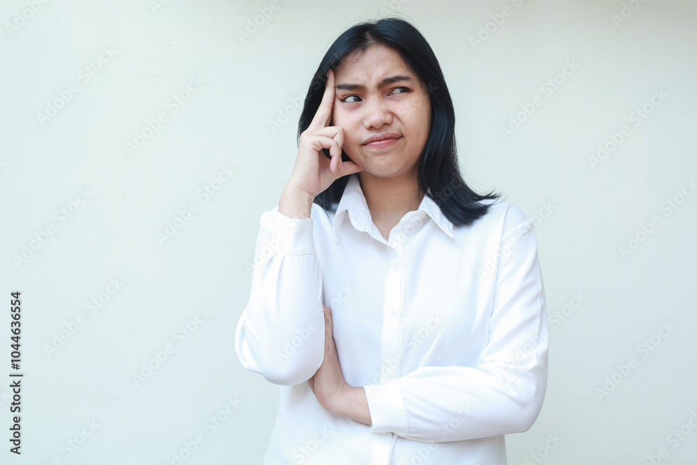 image of pondering asian young woman beautiful secretary looking aside stressed thinking office problem touching her head and folded arms wearing white formal suit, standing image of pondering asian young woman beautiful secretary looking aside stressed thinking office problem touching her head and folded arms wearing white formal suit, standing