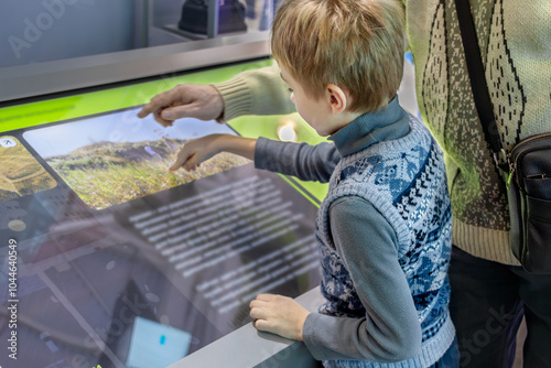 Father and Son Exploring Technology Together on Interactive Screen photo