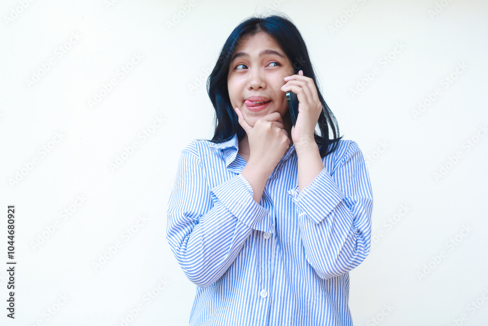 happy asian woman thinking something while talking on smartphone with hands on chin wearing striped shirt isolated on white background happy asian woman thinking something while talking on smartphone with hands on chin wearing striped shirt isolated on white background