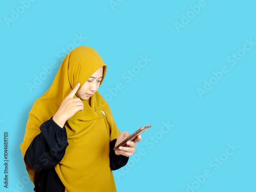 South East asian muslim hijab women using smartphone, thinking pose model.  photo