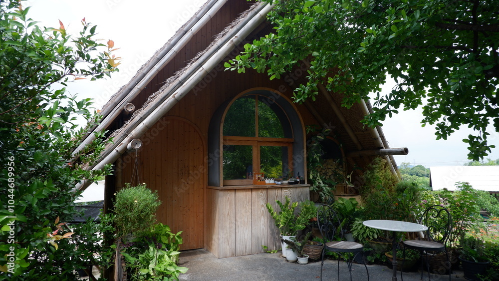A small house under a tree with semicircular windows. A small house under a tree with semicircular windows.
