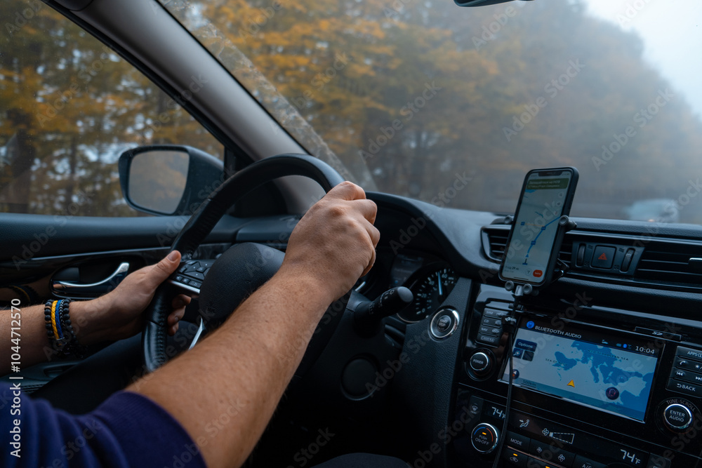 Person Driving by the road at foggy autumn highway