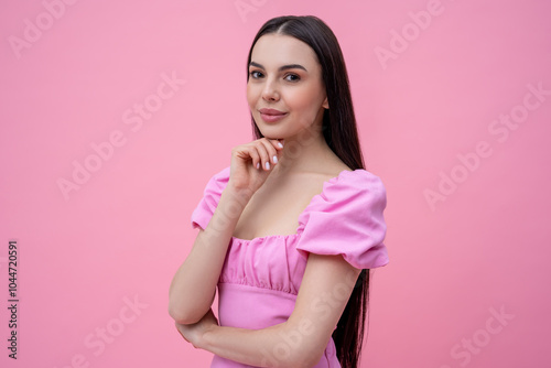 Pretty young long-haired woman in pink dress looking dreamy